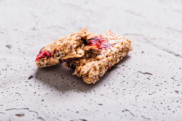 Muesli bar cut in half on a gray concrete background