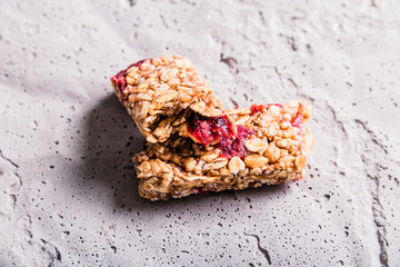 Muesli bar cut in half on a gray concrete background