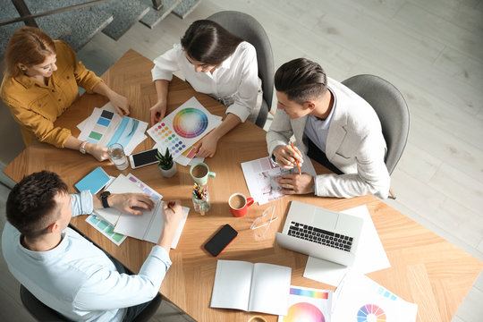 Team of professional designers working together at table in office