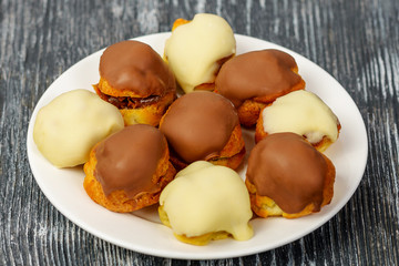 Custard cakes with chocolate cream and glaze of white and milk chocolate