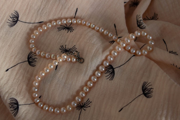 Pink Pearl heart on the linen background. Luxury lifestyle. Holiday decoration. Romantic background.