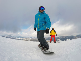 Fototapeta na wymiar Man snowboarding at ski resort. Winter vacation
