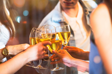 Group of beautiful Asian friendship people celebrating at rooftop party together, gang of best friend having cheerful drink and dance in music fun night lifestyle with light flare and bokeh background