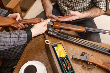customer and salesman disassemble the rifle into parts. young guys make a deal to have firearm in store