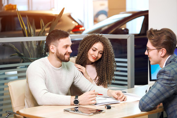 cheerful couple getting available pleasant loan to buy a car. close up photo. successful day, smilig shop assistant enjoying working with customers, favourite work, job, profession