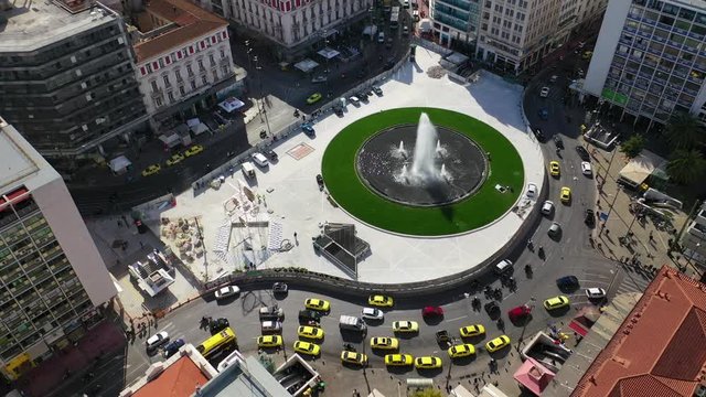 Aerial drone video of recently renovated fountain of famous round square of Omonia in the heart of Athens centre, Attica, Greece