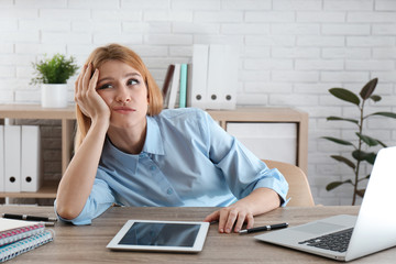 Lazy employee wasting time at table in office