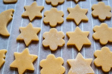 Fototapeta na wymiar Biscuits sablés étoiles et fleurs sur une plaque de cuisson