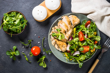 Baked chicken with fresh salad top view.