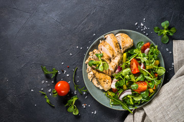 Baked chicken with fresh salad top view.