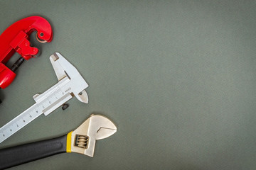 Set of tools for plumber on dark workshop table prepared by professional master before repair or...