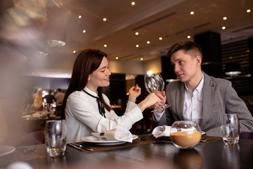 happy caucasian couple have dinner, dating in luxury restaurant. lady and guy enjoy spending time together. indoors
