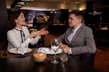 young caucasian married couple have conversation in restaurant. man and woman came to celebrate their anniversary, happy couple in luxury restaurant. romantic place for rendezvous