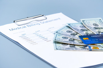 top view picture of medical billing statement,  banknotes and credit card on the gray background