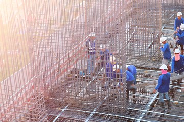 07-01-2020, Bangkok, Thailand. Workers are constructing high-rise building by pouring it onto the steel that has already been prepared on the rooftop beside the Chao Phraya River at the sunset time