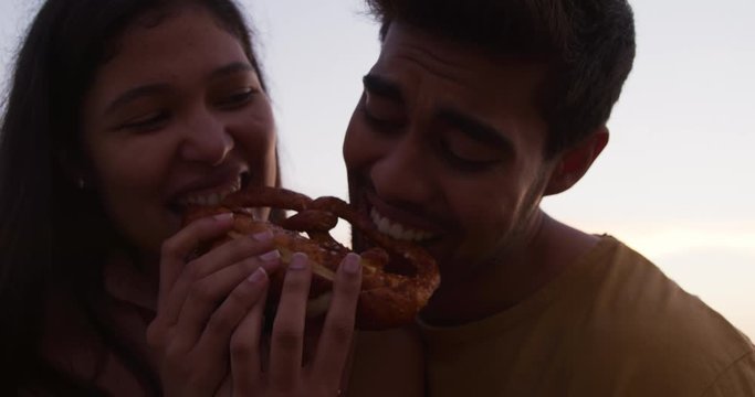 Young Couple Eating Together From Food Truck