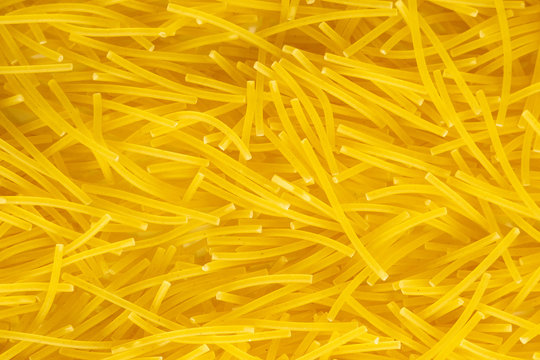 Close Up Of An Italian Macaroni Paste Food Background. Yellow Macaroni Products Macro. Top View. Texture, Place For Text.