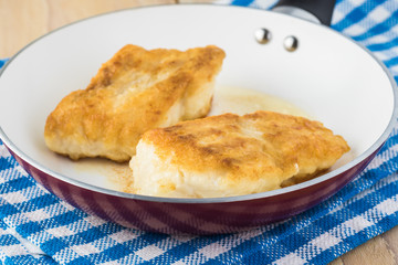 Fried light breaded cod fish.