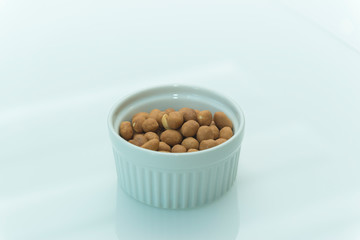 Roasted salty peanuts on white background with copy space.