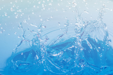 Obraz na płótnie Canvas Drop of water on blue background.Water splash wallpaper.