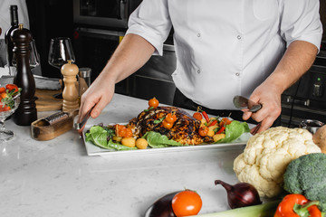 professional chef-cook decorate cooked meat on dish. restaurant, cooking concept