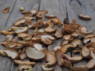 Dried homemade fruit Apple chips or slices on a wooden background. Health benefits of dried fruits, vegetarian food.