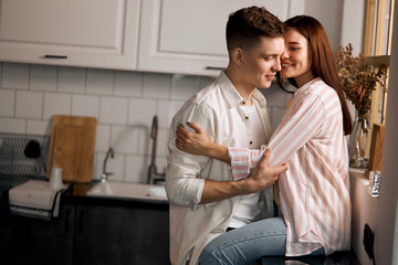 young couple having fun in the kitchen room, close up photo. copy space. i love you.man feeling in...