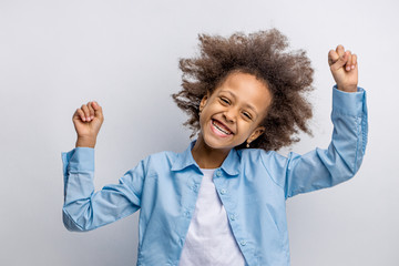 portrait of cheerful girl dancing isolated over white background. little girl shine with happiness,...