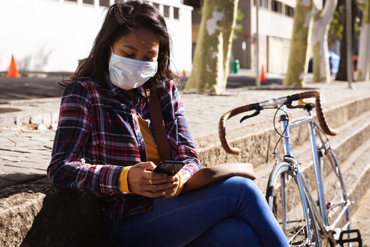Woman wearing a Corona Virus face mask and using her phone