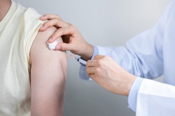 Asian man get coronavirus, flu and measles vaccine shot, vaccination in hospital for good heath, medicine injection vial dose for treatment patient. (select focus)