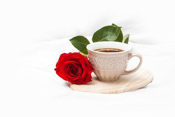 Obraz na płótnie Canvas Black coffee with red rose on a white sheet