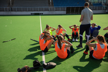 Female hockey players working out on the field