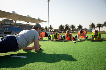 Female hockey players doing cladding on the field