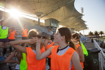 Female hockey players resting and drinking
