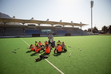 Female hockey players exercising on the field