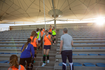 Female hockey players exercising on stairs