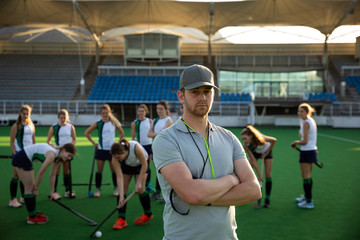 Female hockey players and coach before the match on the field