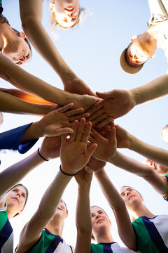 Low angle view female hockey players hands stacking