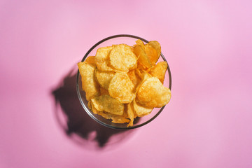 Potato chips on pink background in minimalism style. Flat lay.
