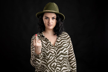 Attractive young woman dressed casually showing fuck you