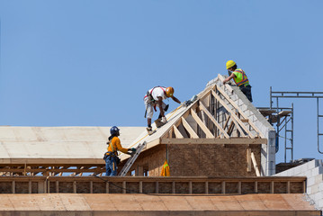 Carpenters are working on the house roof at construction
