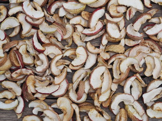 Dried homemade fruit Apple chips or slices on a wooden background. Health benefits of dried fruits.Vegetarian food.