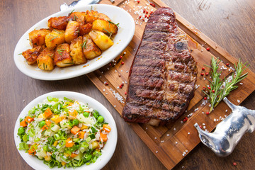 churrasco de T-bone com acompanhamentos