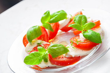 caprese salad with ripe tomatoes and mozzarella cheese with fresh basil leaves. Italian food