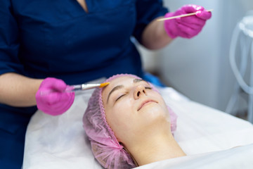 Obraz na płótnie Canvas The girl does the procedure in the beauty salon. Alginate mask, ultrasonic cleaning. Facial skin care. Cosmetology procedures without surgery.