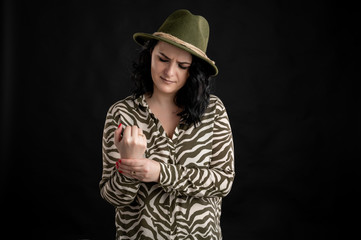 Attractive young woman dressed casually has pain in the right wrist