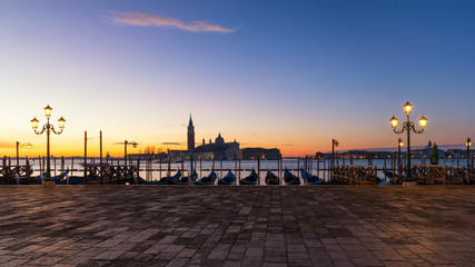 Obraz premium Scenic view of San Giorgio Maggiore, gondolas and lamp at colorful sunrise, Venice, Italy. Sunset in Venice. Gondolas at Saint Mark's Square 