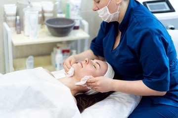 The girl does the procedure in the beauty salon. Alginate mask, ultrasonic cleaning. Facial skin care. Cosmetology procedures without surgery.