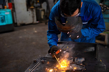 Male workers are welding in industrial work.