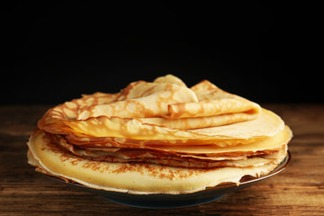 Stack of fresh thin pancakes on wooden table